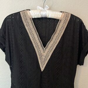 Black short sleeved blouse with neck details.
